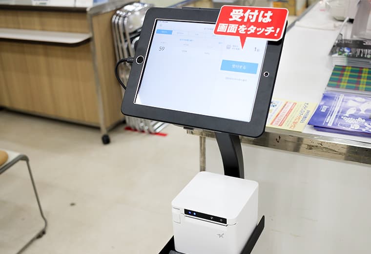 写真:iPadの周りに操作ガイドのポップを設置している様子