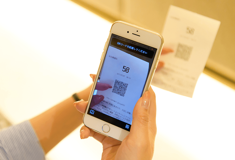 写真:番号券のQRをスマートフォンで読み取っている様子